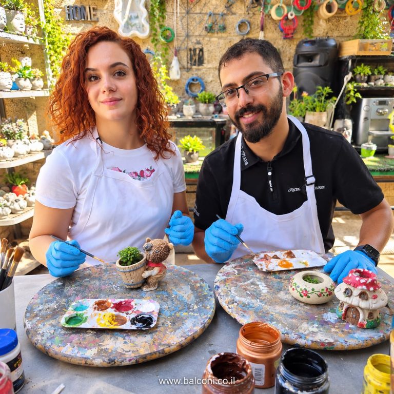 זוג בכפפות צובע יצירות בטון קטנות עם פלטת צבעים