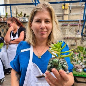 משתתפת מחזיקה עציץ בטון בדמות צב עם סוקולנט